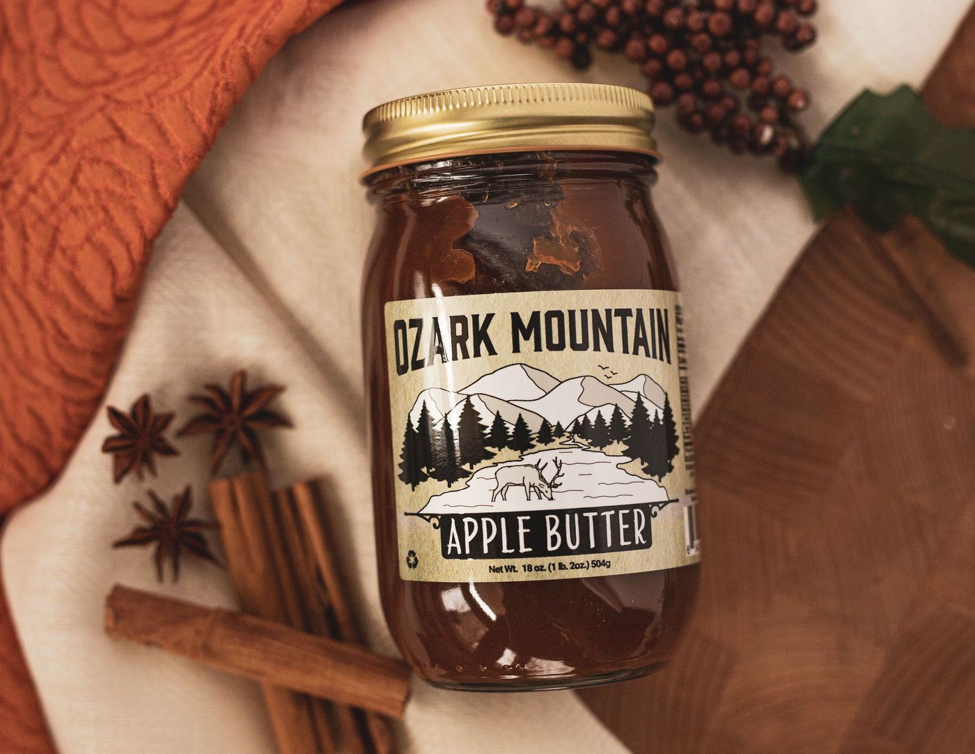 A jar of Ozark Mountain Apple Butter with cinnamon sticks and star anise